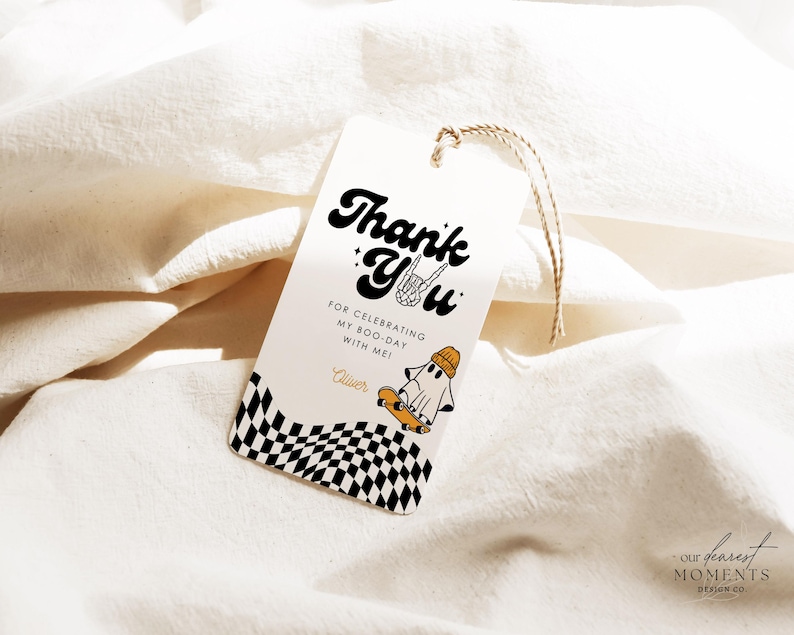 May include: Thank you tag with a checkered background and a ghost on a skateboard. The text reads "Thank You" in a retro font with a ghost holding a skateboard and the words "For celebrating my boo-day with me!"  The tag is tied with twine.