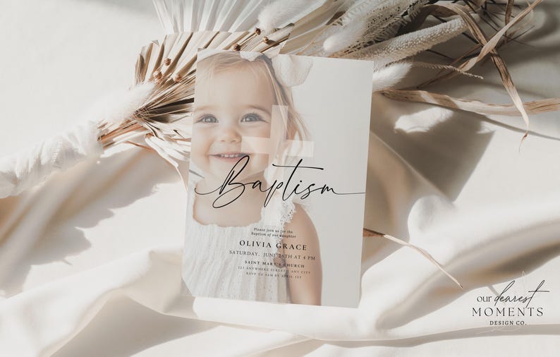 May include: A baptism invitation card featuring a smiling baby girl. The card has the word "Baptism" in elegant script, along with event details. The background includes dried flowers and soft fabric.