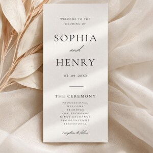 Op de afbeelding: Een verticale witte trouwprogramma-kaart met zwarte schreefletters en cursief schrift. De kaart bevat de tekst: Welcome to the wedding of Sophia and Henry, 02.09.20XX, The Ceremony, Processional, Welcome, Readings, Vow Exchange, Rings Exchange, Pronouncemnt, Recessional, reception to follow.