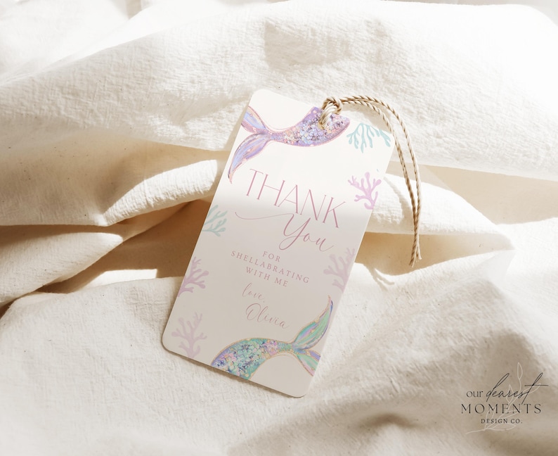 May include: A thank you tag with a mermaid tail design in shades of pink, purple, and blue. The tag says "Thank You" and "For celebrating with me Love, [Name]" with a coral and seaweed design.