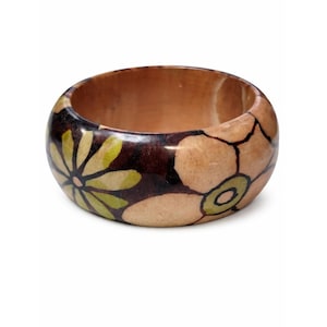 May include: A wooden bangle bracelet with a floral design. The bracelet features a dark brown base with light brown and green floral accents. The bangle is approximately 1 inch wide.