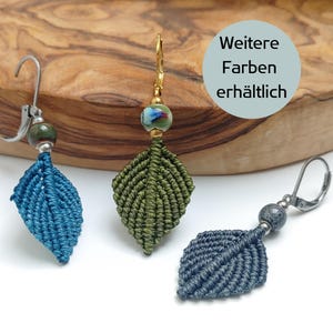 Könnte beinhalten: Drei Paar handgefertigte, blattartige Ohrringe mit verschiedenen farbigen Perlen und Makramee-Details. Die Ohrringe werden auf einer Holzoberfläche präsentiert. Der Text "Weitere Farben erhältlich" ist im Bild sichtbar.