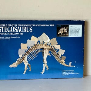 May include: A Stegosaurus wooden skeleton kit from the Museum Series. The kit includes a detailed wooden model of the dinosaur, with dimensions of 78.7 cm x 45.7 cm x 19.7 cm. The box features the text "CREATE A CREATURE FROM BEYOND THE BOUNDARIES OF TIME".