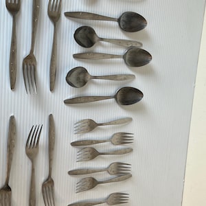 Puede incluir: Un juego de cubiertos, que incluye tenedores y cucharas, con un diseño floral. Los cubiertos están hechos de acero inoxidable y tienen un acabado pulido.