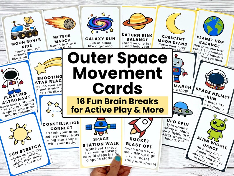 May include: A set of colorful Outer Space Movement Cards with illustrations and instructions for active play. The cards feature space-themed activities like "Moon Rover Ride" and "Alien Wiggle Dance". The cards are held by a hand.