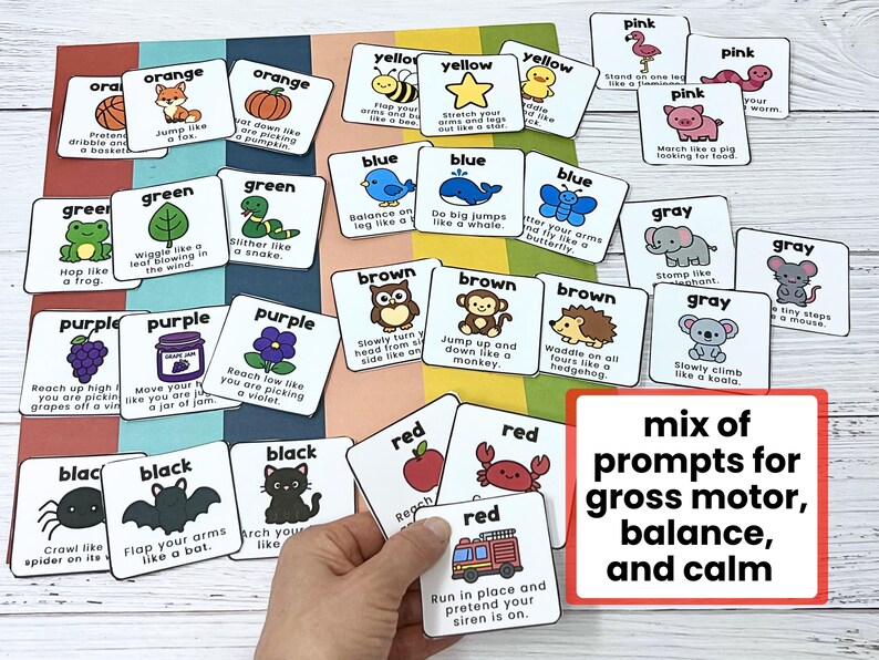 May include: A collection of colorful flashcards with illustrations and text prompts for gross motor skills, balance, and calm activities. The cards feature various colors, animals, and actions, such as "hop like a frog" and "flap your arms like a bat."