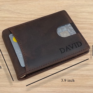 May include: A brown leather wallet with a card slot and the name "DAVID" embossed on the front. The wallet measures 3.9 inches by 2.9 inches and 0.4 inches thick.
