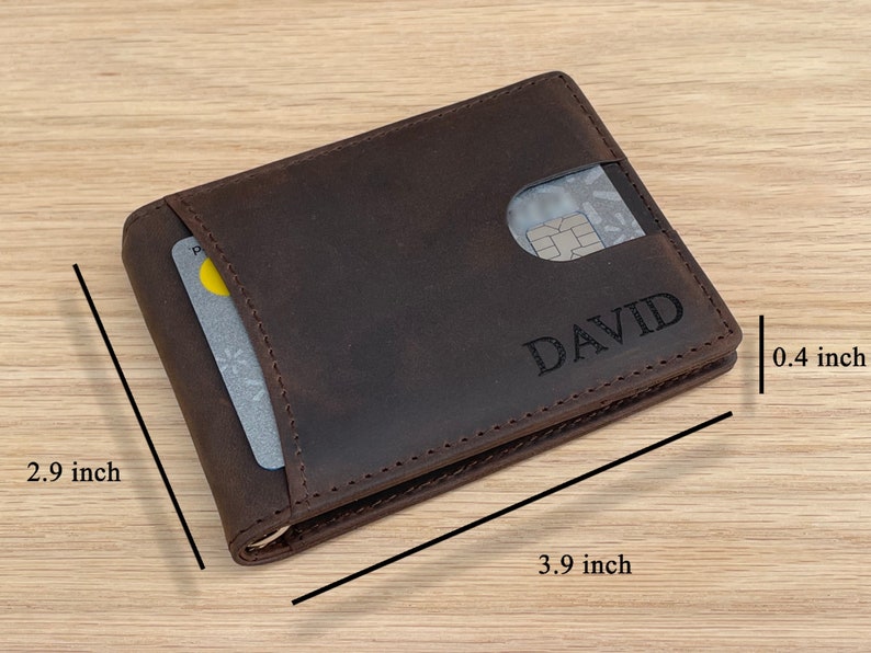 May include: A brown leather wallet with a card slot and the name "DAVID" embossed on the front. The wallet measures 3.9 inches by 2.9 inches and 0.4 inches thick.