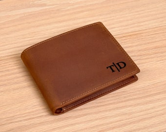May include: A brown leather wallet with the initials "T|D" embossed on the front.