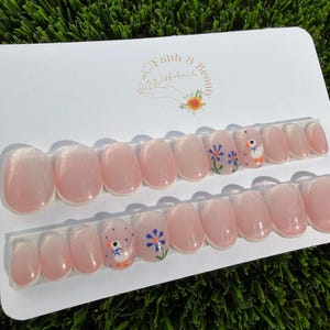 May include: A handmade wooden sign with the text "Welcome" in a playful font. The sign is painted white with a distressed finish, and features a small, decorative heart. Dimensions are approximately 12 inches wide and 6 inches tall.