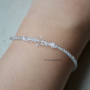 May include: Delicate clear crystal bracelet with a central geometric design. The bracelet is strung with small, round, clear beads. The text "Crystaljewelry" is visible in the image.