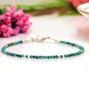 Puede incluir: Un delicado brazalete de cuentas de turquesa y plata. El brazalete está hecho con pequeñas cuentas redondas y tiene un cierre de plata.