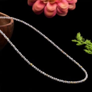 以下が含まれることがあります： 小さな透明な黄色いビーズでできた繊細なネックレス。ネックレスは細い銀色のチェーンに通されています。