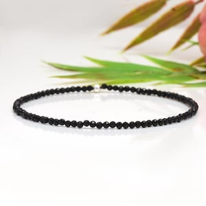 Könnte beinhalten: Ein zartes Armband aus schwarzen Onyxperlen mit einem silbernen Verschluss.