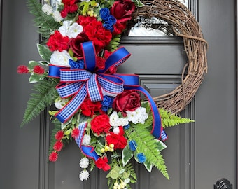 Corona patriótica de vid con flores rojas, blancas y azules y lazo de cuadros vichy.