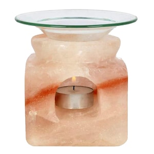 Puede incluir: Un difusor de sal del Himalaya rosa con un plato de vidrio en la parte superior. Una pequeña vela de té se coloca en el centro del bloque de sal.