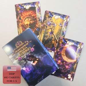 May include: A deck of tarot cards titled Os Mistérios de Maria Mulambo featuring a box with a dark figure and three displayed cards showing a sun, a golden key, and a crescent moon, all decorated with purple floral accents and gold details.