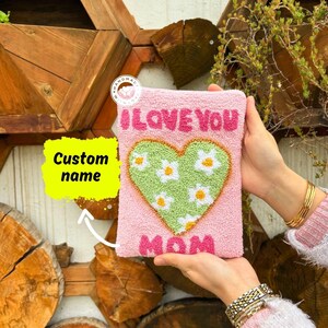 May include: Pink felt pouch with a green heart design and the text "I LOVE YOU MOM".