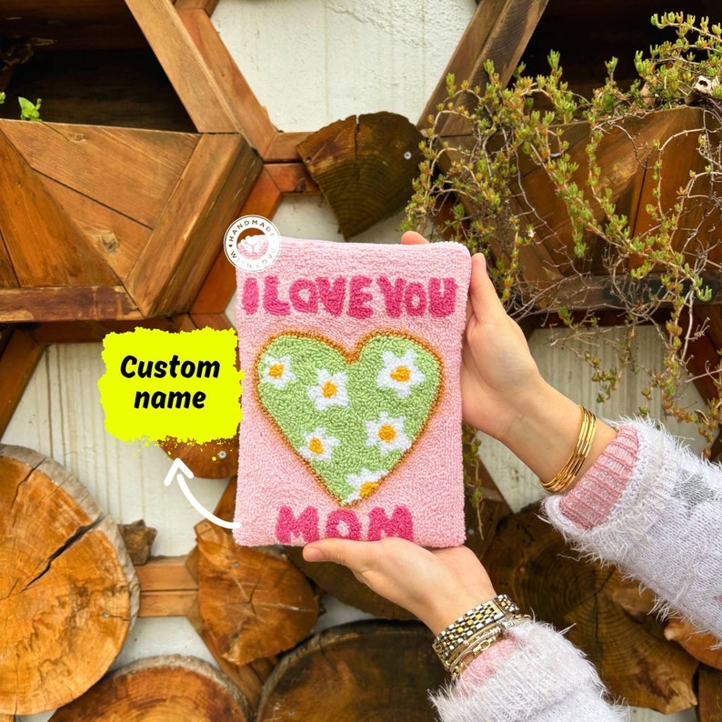 May include: Pink felt pouch with a green heart design and the text "I LOVE YOU MOM".