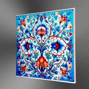 May include: A square ceramic tile with a blue, white, red, and yellow floral pattern. The tile features a repeating design of stylized flowers and leaves.