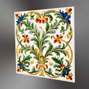 Può includere: Una piastrella di ceramica bianca con un disegno floreale dipinto a mano in verde, giallo e rosso. Il disegno presenta intricati vortici e foglie.