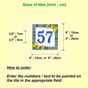 May include: A white ceramic tile with a blue and white mosaic border. The tile has a blue number 57 in the center and is decorated with lemons and flowers. The tile is available in two sizes: 6 inches (15 cm) or 8 inches (20 cm).