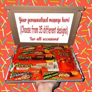 May include: A gift box filled with Reese's peanut butter candy bars. The box lid has a message: "Your personalised message here! (Choose from 35 different designs) For all occasions!" The background is a red pattern with colourful lines.