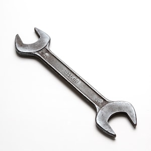 May include: A silver wrench with the text "HOUSo" and "29" printed on it.