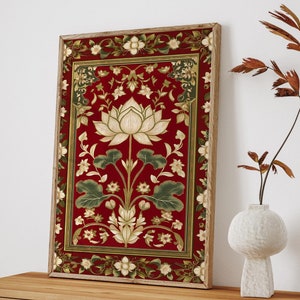 May include: A framed print of a red floral design with a white lotus flower in the centre. The print is surrounded by a gold frame and is hanging on a white wall above a wooden cabinet with woven cane doors.
