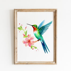 Puede incluir: Una pintura de acuarela enmarcada de un colibr&iacute; en vuelo con una flor rosa. El colibr&iacute; es verde, azul y rojo. La flor es rosa con hojas verdes.