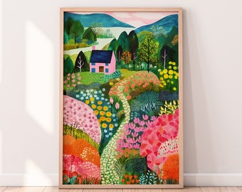 May include: A framed art print featuring a colorful landscape scene. The artwork depicts a pink house with a blue roof nestled among lush greenery, flowers, and trees. A winding path leads through the garden, with mountains in the background. The frame is a light wood color.