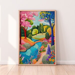 May include: A framed art print depicting a vibrant park scene. The artwork features a blue river winding through a colorful landscape with pink, yellow, and blue trees, a small bridge, and various flowers.