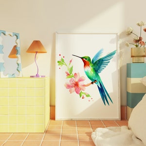 Puede incluir: Una impresi&oacute;n enmarcada en blanco de una pintura de acuarela de un colibr&iacute; con alas verdes y azules, garganta roja y pico largo. El colibr&iacute; est&aacute; posado en una rama con flores rosas.