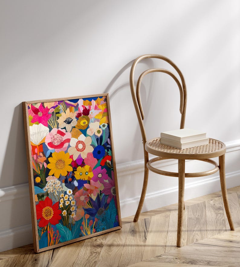 May include: A framed print of a colorful floral illustration. The print features a variety of flowers in shades of pink, red, yellow, blue, and green. The flowers are arranged in a dense, layered pattern, creating a sense of depth and movement. The print is framed in a simple wooden frame.