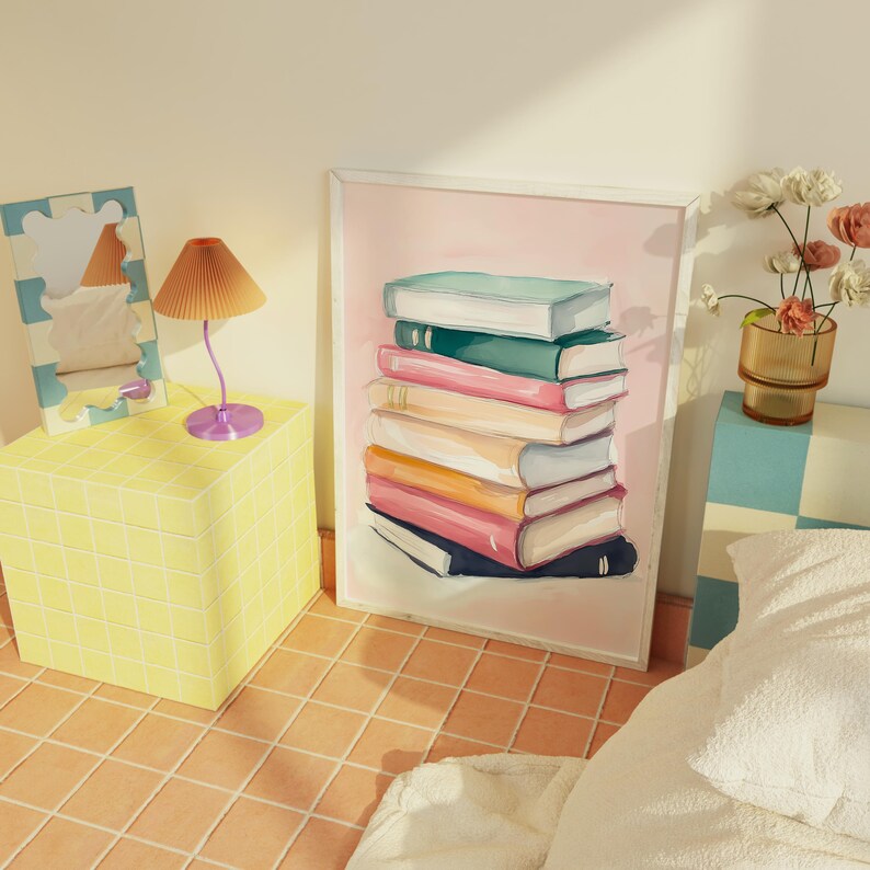 May include: A framed illustration of a stack of colorful books on a pink background. The books are arranged in a staggered pattern, with the top book being the largest and the bottom book being the smallest. The books are all different colors, including pink, blue, green, and yellow.