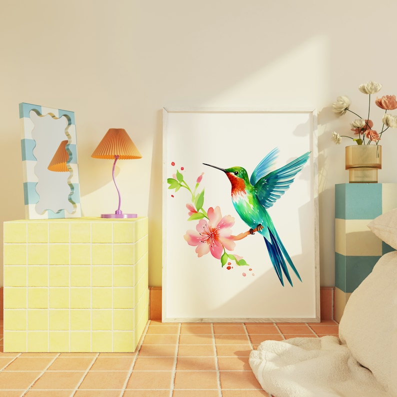Puede incluir: Una impresi&oacute;n enmarcada en blanco de una pintura de acuarela de un colibr&iacute; con alas verdes y azules, garganta roja y pico largo. El colibr&iacute; est&aacute; posado en una rama con flores rosas.