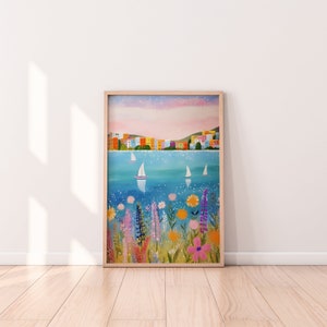 May include: A framed painting of a colorful cityscape with sailboats on a blue body of water. The foreground features a field of pink, purple, and yellow flowers.