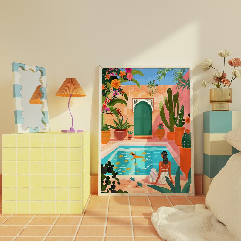 May include: A colorful illustration of a Moroccan courtyard with a swimming pool, potted plants, and a woman sitting by the water. The illustration is framed in a white frame.