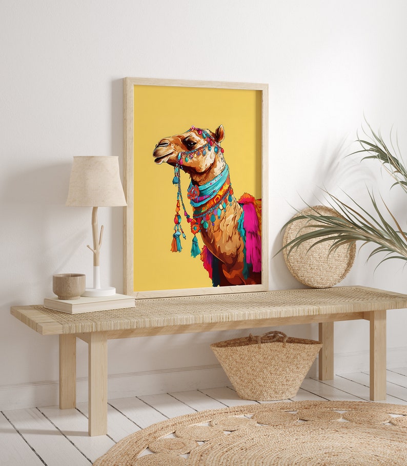 May include: A framed print of a camel with colorful decorations on a yellow background. The camel is facing to the right and has a blue and turquoise collar with tassels.