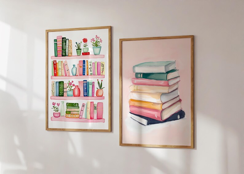 May include: Two framed watercolor paintings of books. The first painting shows a pink bookshelf with colorful books, plants, and vases. The second painting shows a stack of colorful books on a pink background.