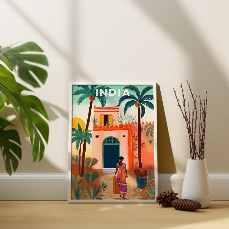 May include: A framed illustration of a colorful building with a woman in a pink and blue dress walking towards the entrance. The building is surrounded by palm trees and the text "INDIA" is at the top of the image.