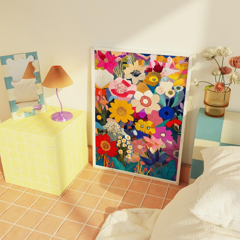 May include: A colorful floral print with a variety of flowers in shades of pink, red, yellow, blue, and green. The print is framed in a white frame and is hanging on a wall.