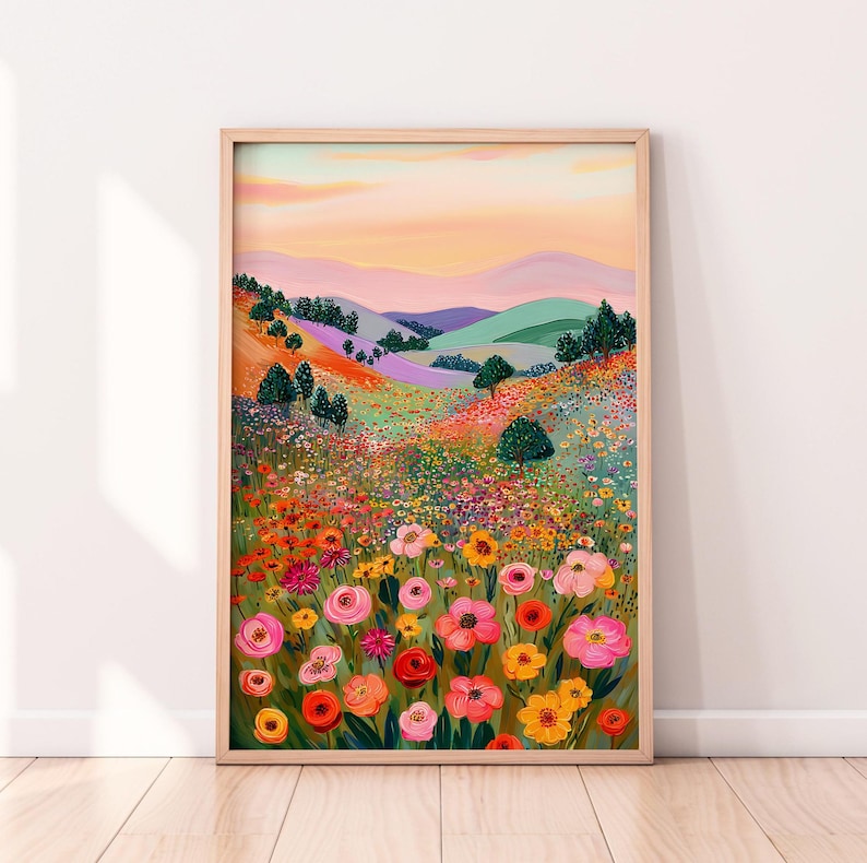 May include: A framed art print featuring a vibrant landscape painting. The artwork depicts a colorful field of flowers in the foreground, with rolling hills and a sunset sky in the background. The color palette includes pinks, oranges, yellows, and greens.