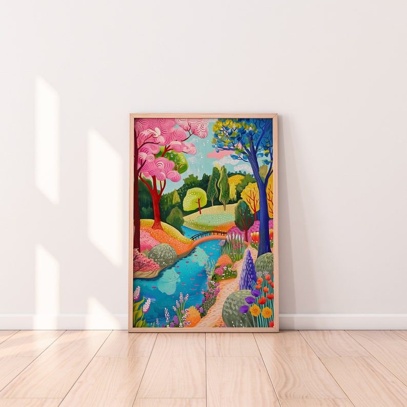 May include: A framed art print depicting a vibrant park scene. The artwork features a blue river winding through a colorful landscape with pink, yellow, and blue trees, a small bridge, and various flowers.
