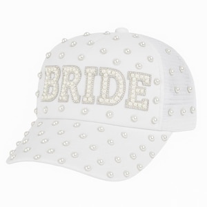 May include: White baseball cap with the word "BRIDE" spelled out in pearl-like beads. The cap is decorated with scattered pearl-like beads and has a mesh back.