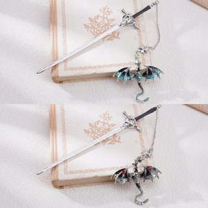 May include: Two silver sword-shaped hair clips with dangling dragon charms. One dragon is green and the other is black.