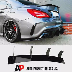 May include: A silver car with black alloy wheels and a black rear diffuser. The car's rear lights are red. A separate black rear diffuser with vertical fins is displayed below the car. The text "AP AUTO PERFECTIONISTS UK." is visible.