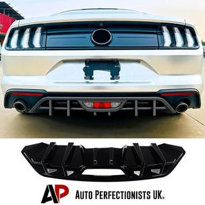 May include: The rear of a white car with black detailing, including a diffuser and exhaust pipes. A black car diffuser is shown below. The text "AUTO PERFECTIONISTS UK" is present.