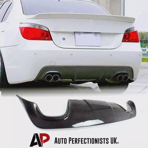 May include: White car with a rear spoiler and dual exhaust pipes. A black carbon fibre rear diffuser is displayed below the car. The text "AP AUTO PERFECTIONISTS UK." is visible at the bottom.