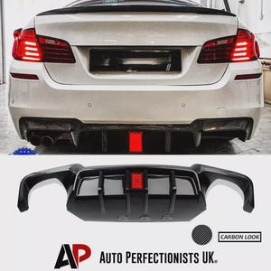 May include: Rear view of a white car with a carbon fibre-look diffuser and a red central light. A separate diffuser is shown with the text "CARBON LOOK" and the "AUTO PERFECTIONISTS UK." logo.